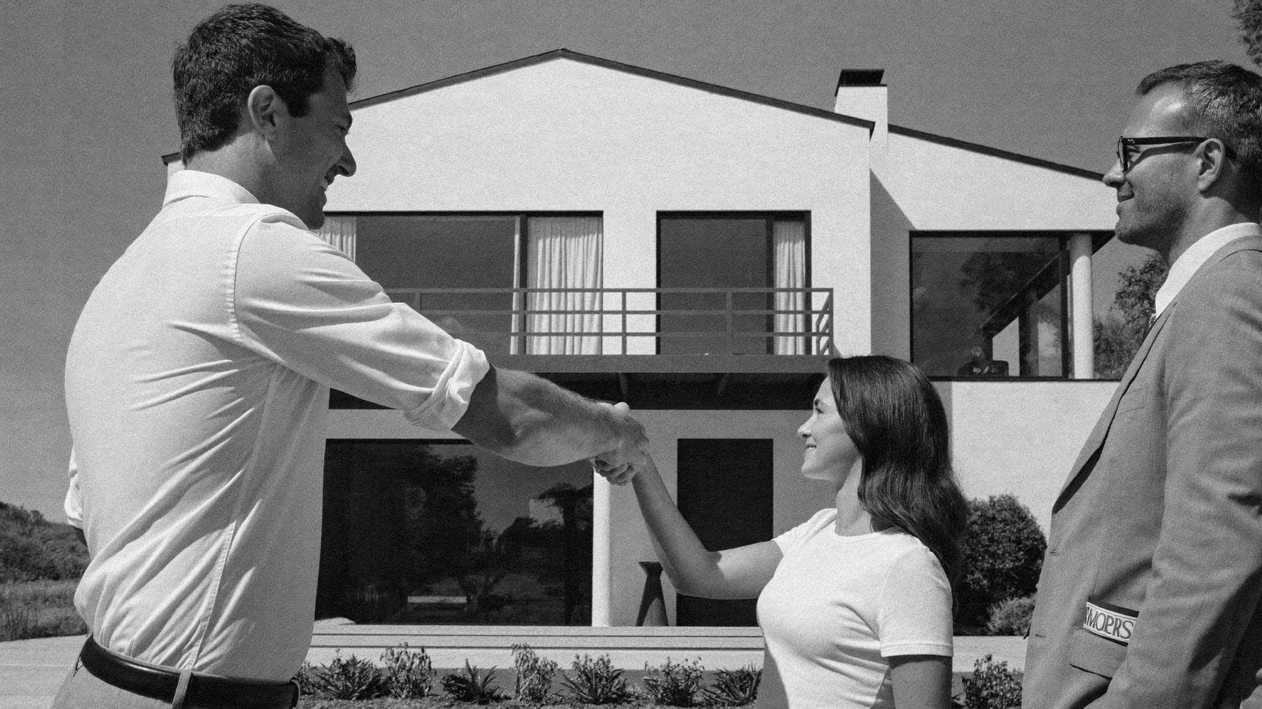Agente inmobiliario saludando a una pareja frente a una villa